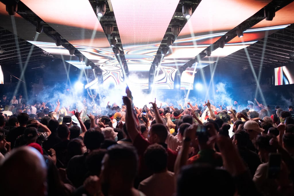 Crowd dancing under stage lights in a nightclub
